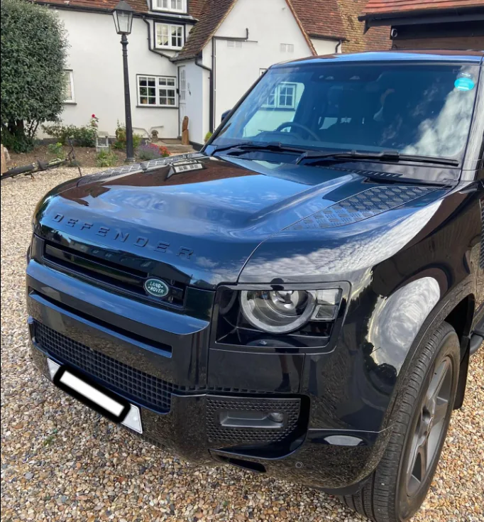 Black Land Rover Defender with a clean reflective finish